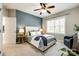 Cozy bedroom with a blue accent wall, ceiling fan, and a large window for natural light at 405 Five Leaf Ln, Waxhaw, NC 28173