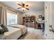 Serene bedroom featuring a large window, a ceiling fan, a wooden bookcase, a writing desk, and plush carpeting at 405 Five Leaf Ln, Waxhaw, NC 28173