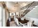 Formal dining room with hardwood floors, a staircase with iron railings, and an open view to the living area at 405 Five Leaf Ln, Waxhaw, NC 28173