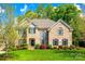 Spacious brick home with manicured lawn, landscaping, and driveway at 405 Five Leaf Ln, Waxhaw, NC 28173