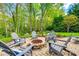 Stone fire pit surrounded by Adirondack chairs in a landscaped backyard at 405 Five Leaf Ln, Waxhaw, NC 28173