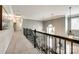Carpeted hallway with black iron railing overlooking the entry; features decorative pendant lighting at 405 Five Leaf Ln, Waxhaw, NC 28173