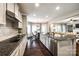Well-lit kitchen featuring stainless steel appliances, granite countertops, an island with bar seating, and a dining area at 405 Five Leaf Ln, Waxhaw, NC 28173