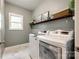Efficient laundry room equipped with modern washer and dryer, marble floors, and ample shelving for storage at 405 Five Leaf Ln, Waxhaw, NC 28173