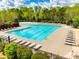 A community swimming pool sits surrounded by lounge chairs and green landscaping on a sunny day at 405 Five Leaf Ln, Waxhaw, NC 28173