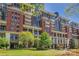 Stunning brick condominium building with balconies, lush landscaping, and verdant lawn area on a sunny day at 435 S Tryon St, Charlotte, NC 28202