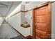 Hallway featuring a wooden doorway, neutral paint, unique patterned carpet, and decorative ledge with subtle lighting at 435 S Tryon St, Charlotte, NC 28202