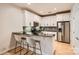 Modern kitchen with stainless steel appliances, white cabinets, and stylish black countertops with barstool seating at 435 S Tryon St, Charlotte, NC 28202