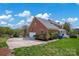 Long driveway leads to a brick house with a two-car garage surrounded by lush landscaping at 4405 3Rd Nw St, Hickory, NC 28601
