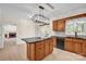 Kitchen featuring wood cabinetry, black appliances, and a center island with cooktop at 4405 3Rd Nw St, Hickory, NC 28601