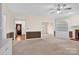 Bright living room featuring neutral carpet, built-in shelving, and an entryway with a decorative glass door at 4405 3Rd Nw St, Hickory, NC 28601