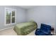 Neutral bedroom featuring a window with white shutters and a comfortable chair at 4813 Carving Tree Dr, Mint Hill, NC 28227
