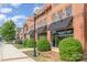 Brick building with black awnings, street lamps, and trimmed bushes under a blue sky with clouds at 4813 Carving Tree Dr, Mint Hill, NC 28227