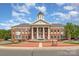 Exterior of Town of Mint Hill building with fountain, columns, and flags under a cloudy sky at 4813 Carving Tree Dr, Mint Hill, NC 28227