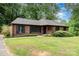Traditional brick home with black shutters, tidy landscaping, and a spacious front lawn at 4813 Carving Tree Dr, Mint Hill, NC 28227