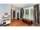 Bright living room featuring hardwood floors, shutters, and a purple door at 4813 Carving Tree Dr, Mint Hill, NC 28227