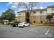 Brick apartment building with tan siding, mature landscaping, and ample parking spaces for residents and guests at 4816 Spring Lake Dr # B, Charlotte, NC 28212