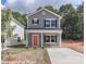 Charming two-story home with gray siding, a bright coral door, and well-manicured landscaping at 552 Ridge Ave, Mooresville, NC 28115