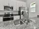 Close up of modern kitchen featuring granite countertops, stainless steel appliances, and stylish faucet at 552 Ridge Ave, Mooresville, NC 28115