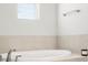 Clean bathroom featuring a soaking tub and tiled walls at 5532 Muckross Ln, Fort Mill, SC 29707