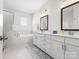 Bright bathroom featuring double sinks, a soaking tub, and tiled floors at 5532 Muckross Ln, Fort Mill, SC 29707