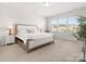 Bright bedroom featuring neutral colors, a large bed, and a window offering natural light at 5532 Muckross Ln, Fort Mill, SC 29707
