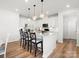 Kitchen featuring stainless appliances, white cabinets, island, bar seating and pendant lighting at 5532 Muckross Ln, Fort Mill, SC 29707