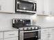 Up close, the stainless oven and microwave are displayed alongside white cabinets at 5532 Muckross Ln, Fort Mill, SC 29707