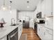 Bright kitchen with stainless appliances, island with a sink, and wood floors at 5532 Muckross Ln, Fort Mill, SC 29707