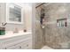 Bathroom features a gray tile shower, white vanity, and well-lit mirror at 557 Hunter Ave, Kannapolis, NC 28083