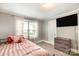 Bedroom features neutral paint, carpet, a TV, and a black metal bed frame with pink comforter at 557 Hunter Ave, Kannapolis, NC 28083