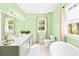 Bathroom features a long vanity, toilet, tub, and two windows providing natural light at 621 N 9Th St, Albemarle, NC 28001