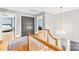 Bright upstairs hallway with hardwood floors, chandelier, and staircase with wooden railing and spindle balusters at 621 N 9Th St, Albemarle, NC 28001