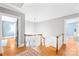 Upstairs hallway with hardwood floors, white walls, and access to several rooms at 621 N 9Th St, Albemarle, NC 28001