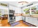 Open kitchen featuring stainless steel appliances, tile backsplash, and view to dining room at 621 N 9Th St, Albemarle, NC 28001