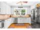 Kitchen boasts stainless steel appliances, white cabinets and tile backsplash for a sleek design at 621 N 9Th St, Albemarle, NC 28001