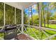 View of outdoor grill on screened porch with brick flooring and view of beautiful wooded backyard at 621 N 9Th St, Albemarle, NC 28001
