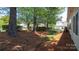 Backyard featuring mature trees, green space, and home exterior at 6222 Meadow Glen Ln, Harrisburg, NC 28075