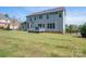 Spacious backyard with a deck, lush green grass, and a charming black fence at 6352 Willow Farm Dr, Denver, NC 28037