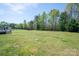 Large backyard surrounded by a black fence and mature trees offers a serene, private outdoor space at 6352 Willow Farm Dr, Denver, NC 28037