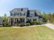 Two-story home showcasing a well-manicured lawn and a charming front porch with stone accents at 6352 Willow Farm Dr, Denver, NC 28037