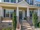 Home's covered front porch with stone pillars and black railing, perfect for relaxing outdoors at 6352 Willow Farm Dr, Denver, NC 28037