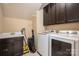 Well-equipped laundry room with dark cabinetry, sink, and modern washer and dryer at 6352 Willow Farm Dr, Denver, NC 28037