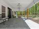 Covered back porch features overhead lighting, stone floors, seating, and backyard views at 6724 Brushwood Dr, Charlotte, NC 28262