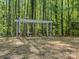 Picturesque backyard featuring a charming swing, flowers, and serene wooded setting at 6724 Brushwood Dr, Charlotte, NC 28262