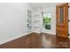 Inviting bedroom with hardwood floors, built-in shelving, and a charming wooden door at 6724 Brushwood Dr, Charlotte, NC 28262