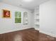 Bright bedroom featuring hardwood floors, built-in shelving, and a charming window with natural light at 6724 Brushwood Dr, Charlotte, NC 28262
