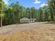 Exterior daytime shot of renovated home, surrounded by large trees, featuring a three car garage at 6724 Brushwood Dr, Charlotte, NC 28262