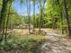 Secluded home nestled among trees with a long gravel driveway and picturesque white fence at 6724 Brushwood Dr, Charlotte, NC 28262