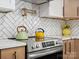 Close up of updated kitchen featuring herringbone backsplash, modern appliances, and quartz countertops at 6724 Brushwood Dr, Charlotte, NC 28262